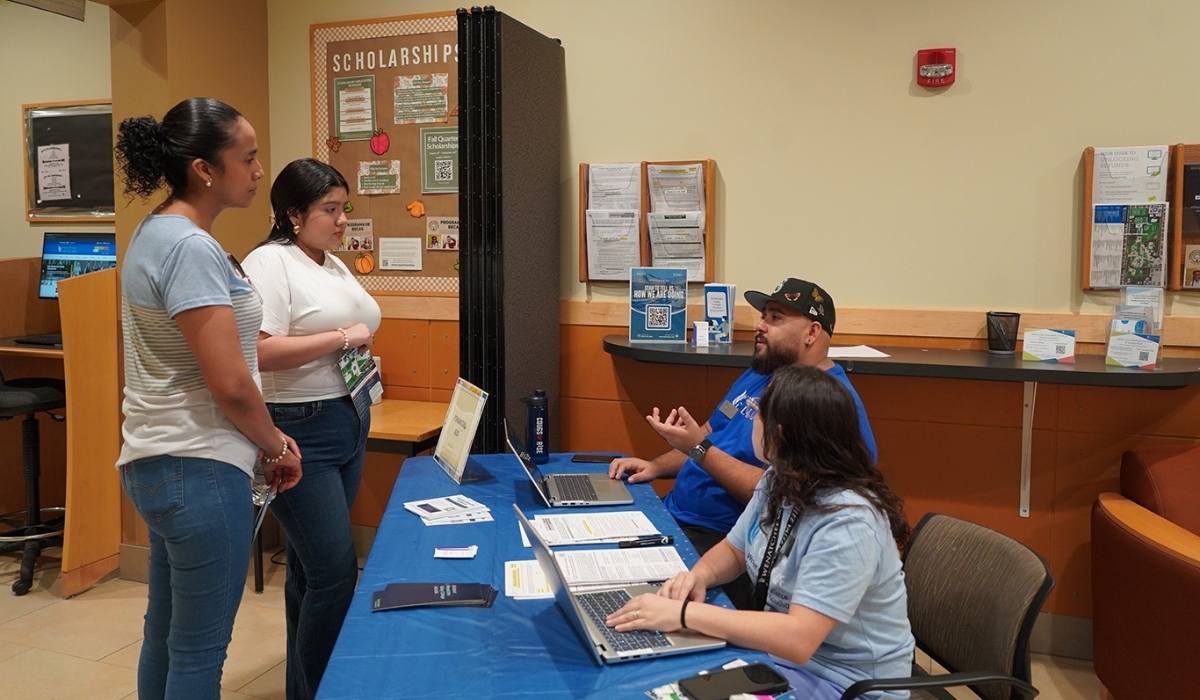 WVC Financial Aid director César talking to students at a table