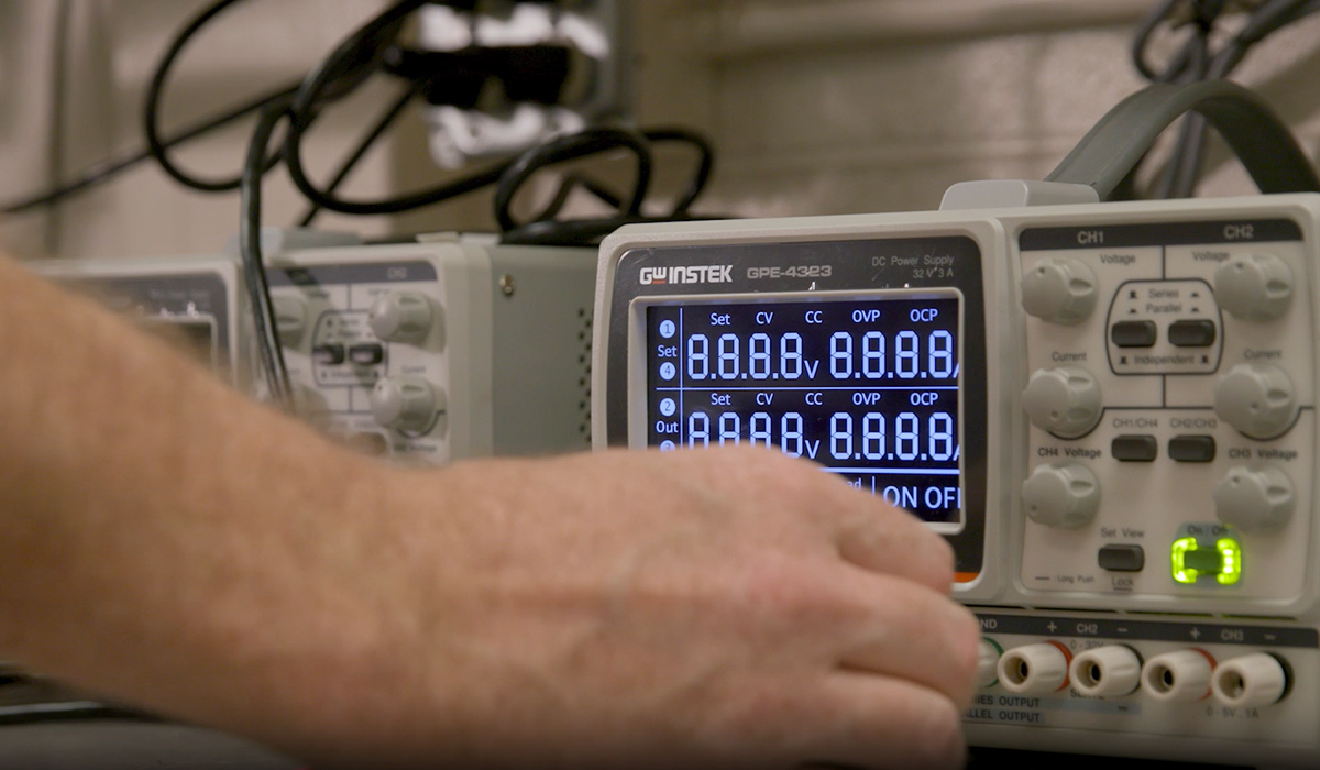 A hand turns on a controls system.