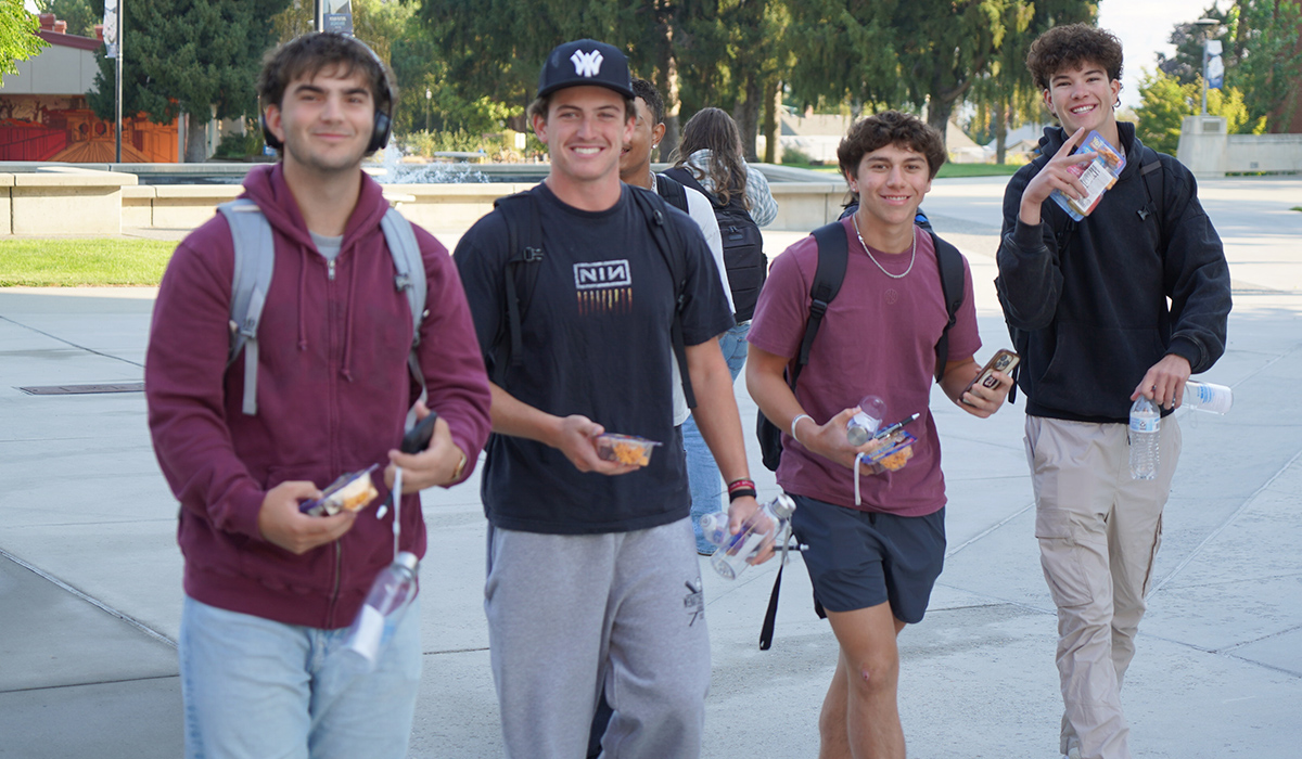 A group of male students carrying snacks walk across WVC's Wenatchee campus