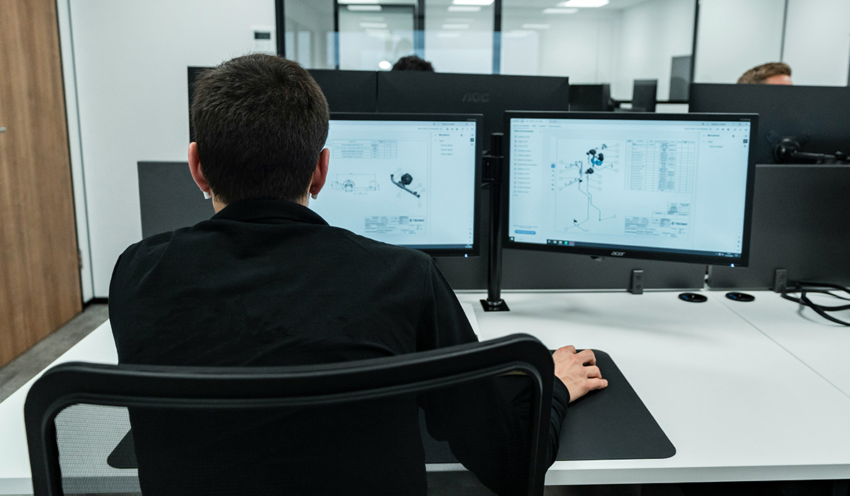 A person sits at a computer working on a design.