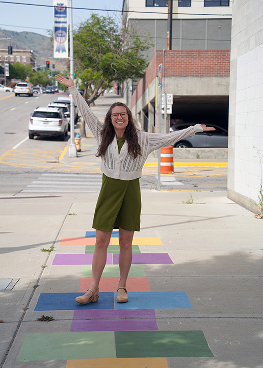 Ellen Bruex stands next to a sidewalk mural that she created.