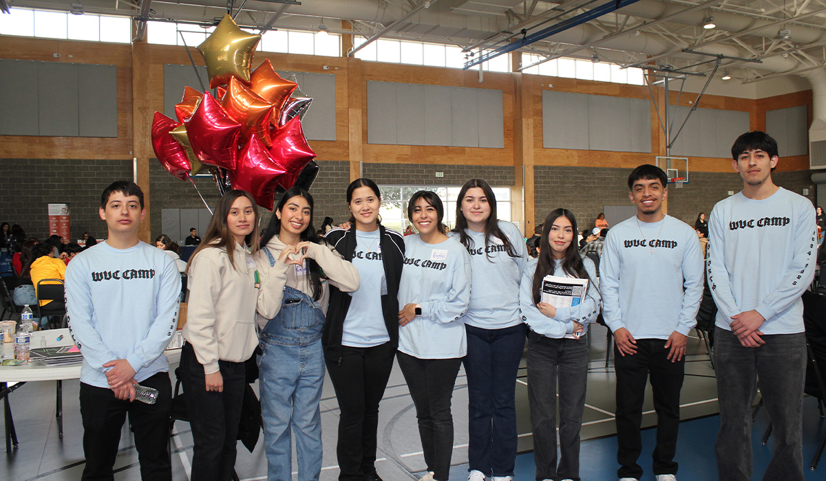 CAMP students wearing blue and black CAMP shirts stand together in a group.